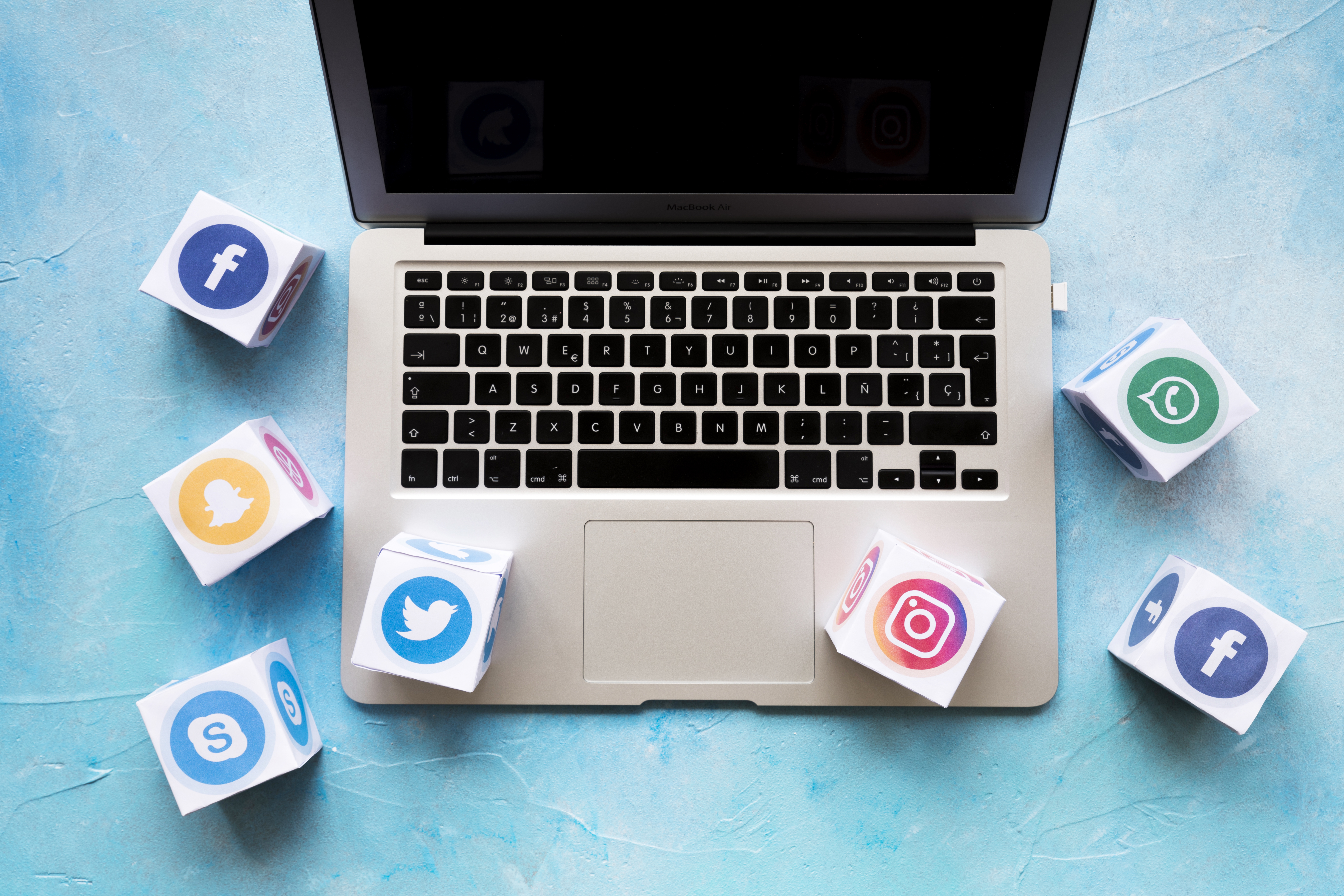 social-media-icon-blocks-laptop-blue-background social-media-icon-blocks-laptop-blue-background